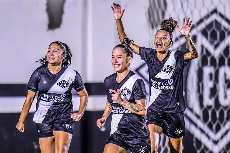 Três jogadoras com uniformes alvinegros comemoram em campo